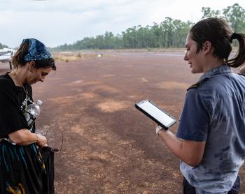Two people standing on airtstrip in rainy weather