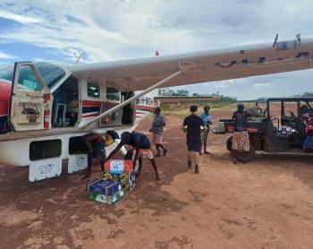 people unloading supplies from aircraft