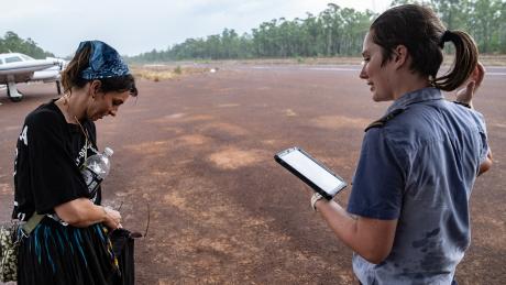 Two people standing on airtstrip in rainy weather