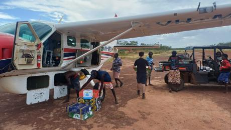 people unloading supplies from aircraft