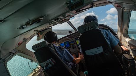 Two pilots in the cockpit of a banking aircraft