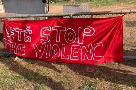 A learge red banner that reads "Stop the violence."