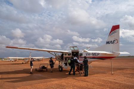 Aircraft and ambulance stretcher on tarmac