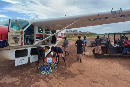 people unloading supplies from aircraft