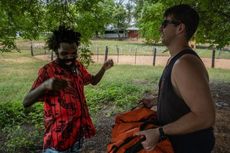two men laughing in the shade of a tree