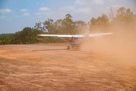 MAF plane on red dirt airstrip.