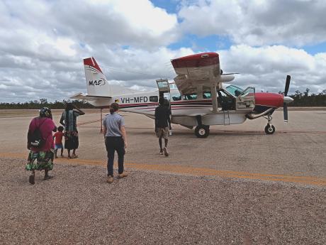 Pilot and passengers walking out to aircraft on tarmac