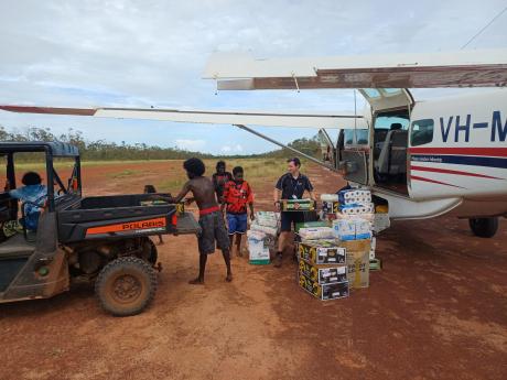 unloading aircraft on red dirt airstrip