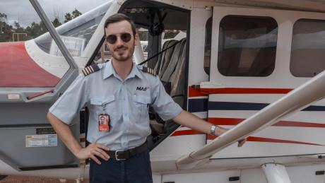 pilot standing in front of aircraft on tarmac