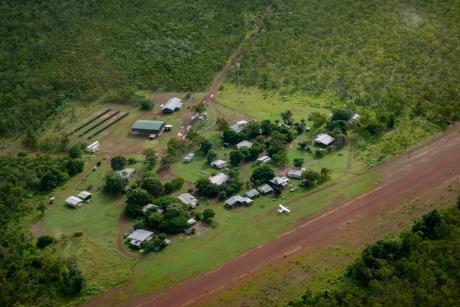 aerial view of homeland buildings adjacent to red dirt airstrip