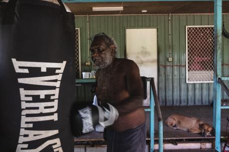 man punching boxing bag in physiotherapy session
