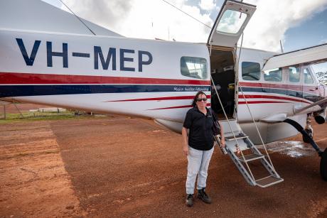 Woman in front of aircraft on aiprort tarmac