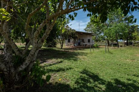 Small corrugated iron community clinic building surrounded by lawns and trees